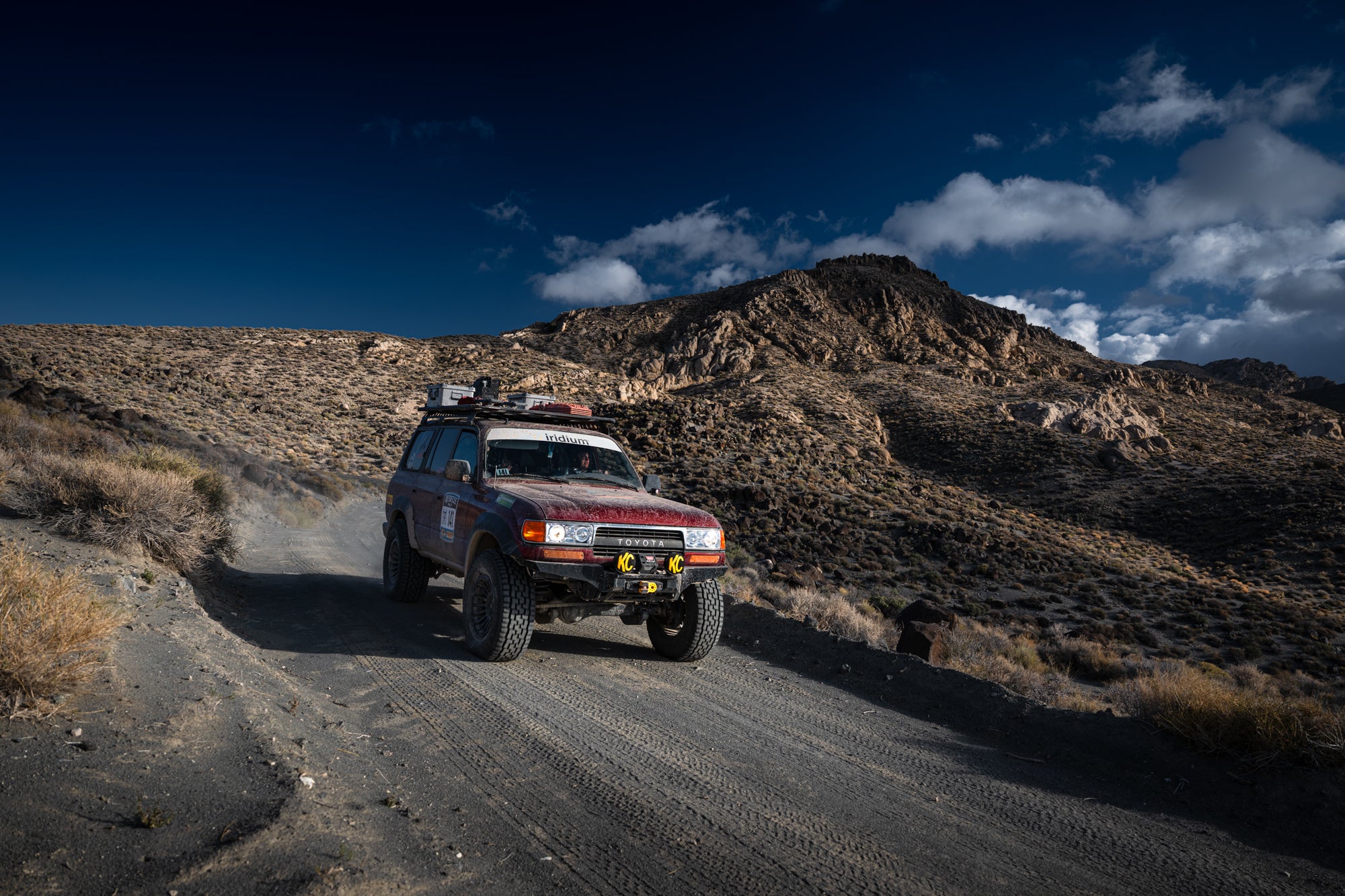 Off-road vehicle on a dirt road with mountains in the background
