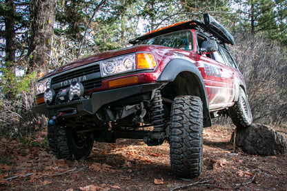 The Rugged Overland Toyota 80 Series Land Cruiser flexing on a rock, showing the SuperPro Suspension parts.